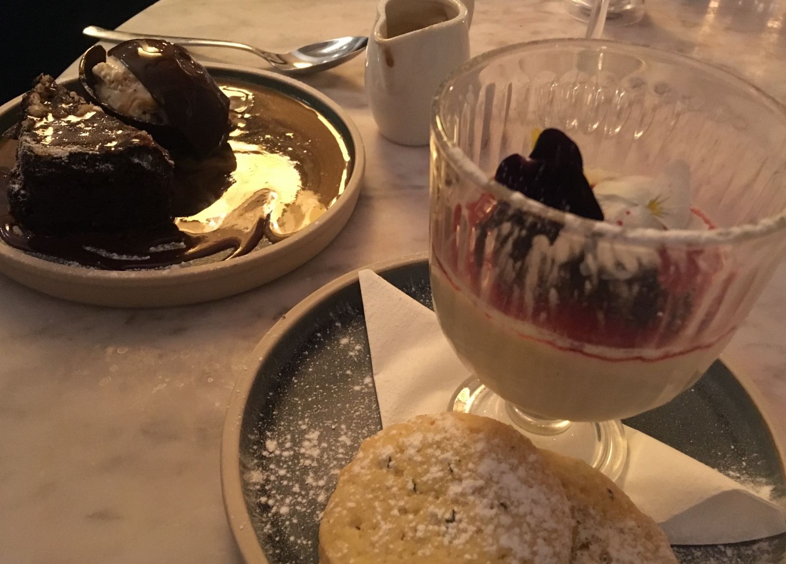 Lemon posset with mixed berry compote and chocolate dome with hazelnut torte at Aqua.
