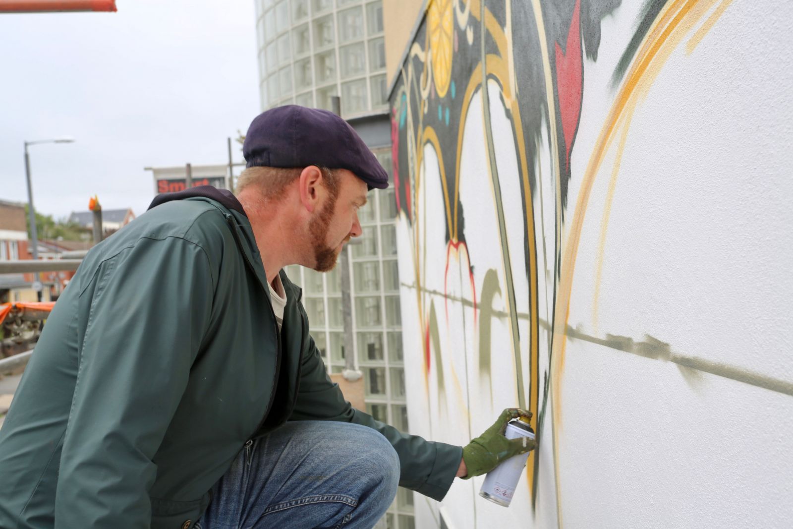 Local artist Rob Wheeler works on a mural outside the St Pauls Learning Centre.