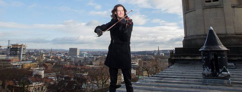Thomas Gould with his violin on the roof of St George's in Bristol